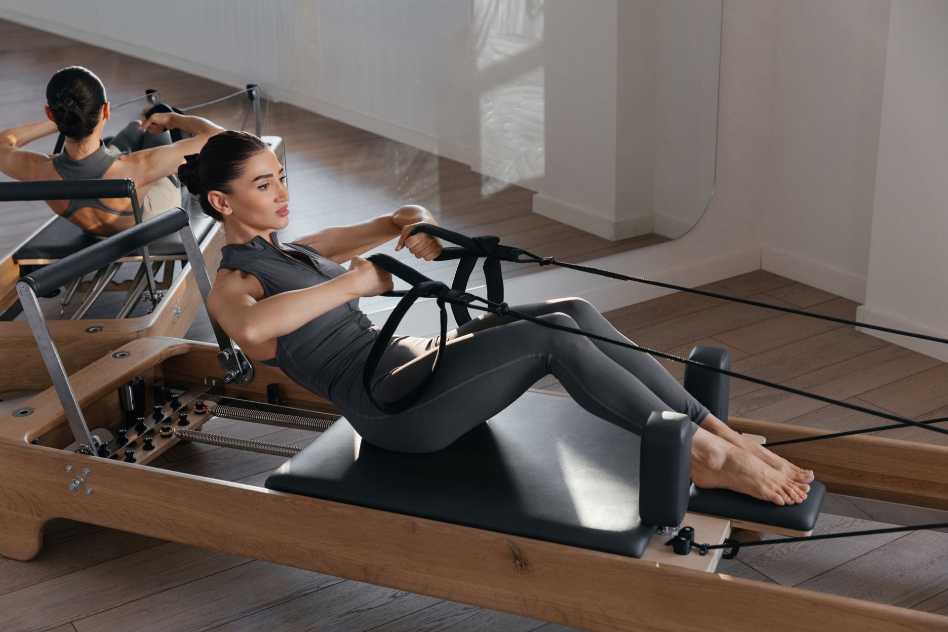 Pilates reformer training in a bright studio with limited-capacity booking.